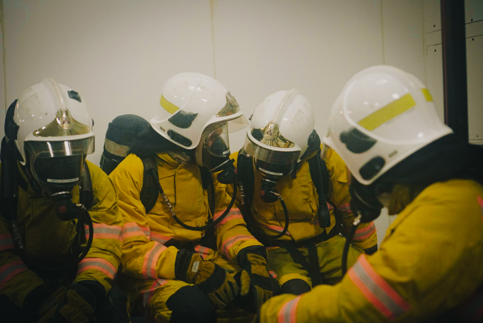 Four firefighters with helmets and suits